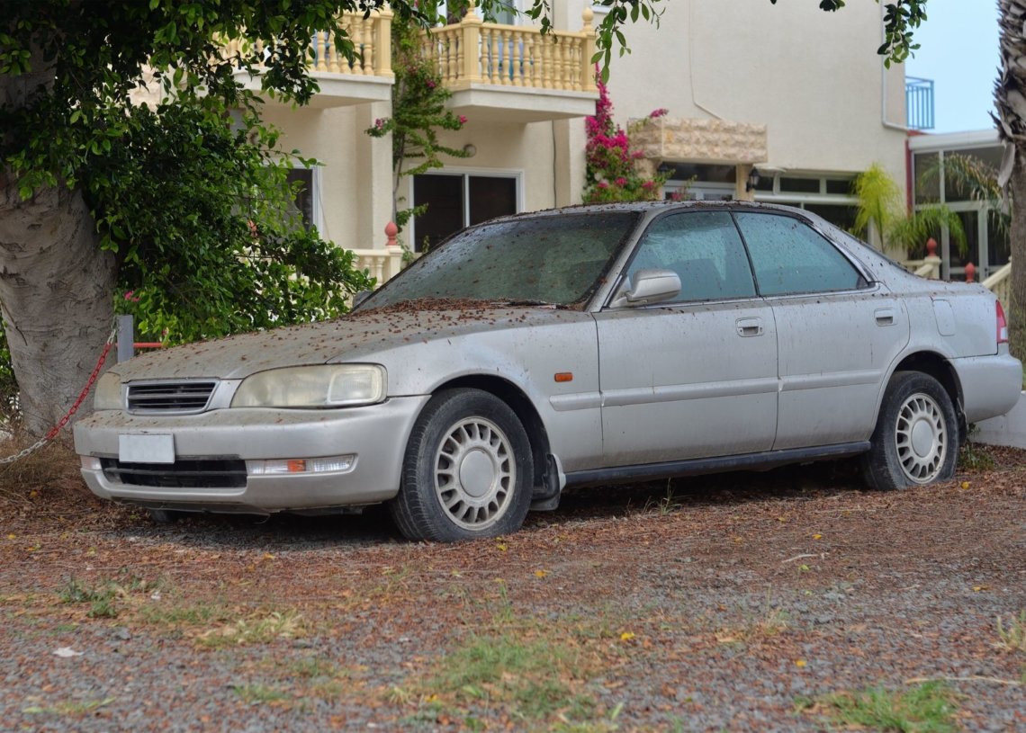 An old car parked on the side of a road in Autumn