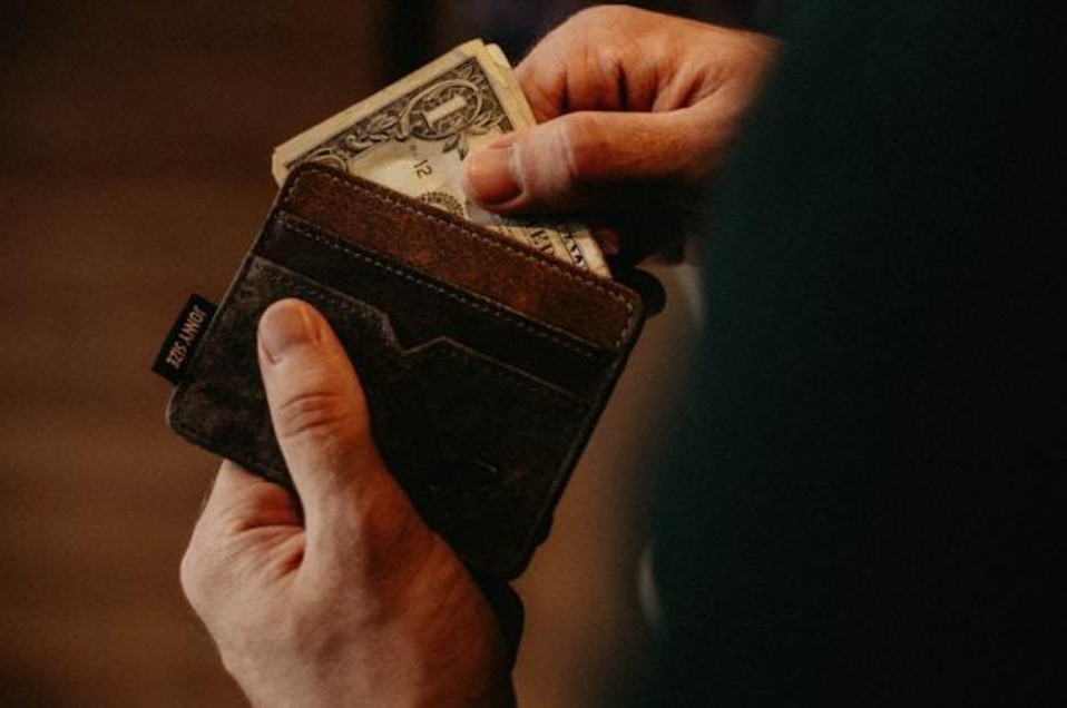 Person putting money into a wallet