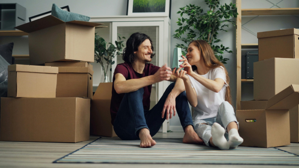 Smiling Couple Sitting on Floor in House