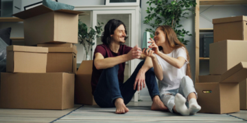 Smiling Couple Sitting on Floor in House