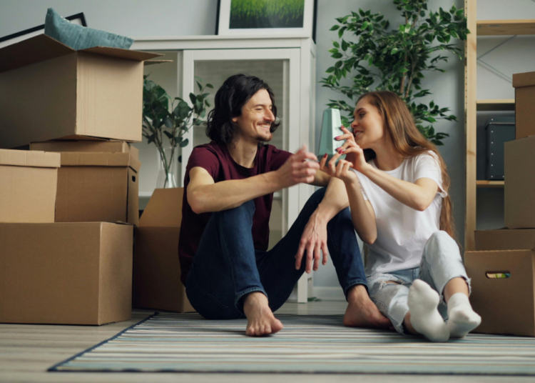 Smiling Couple Sitting on Floor in House
