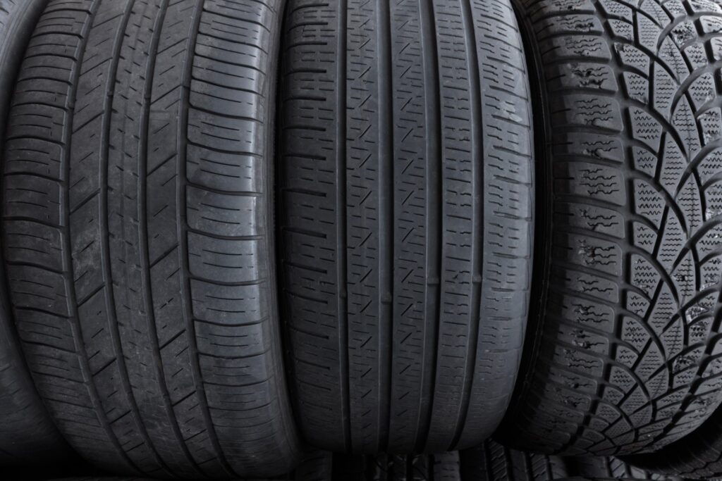 A lineup of three tires, upright, facing the viewer. Each tire is a different size with a distinct tread pattern.