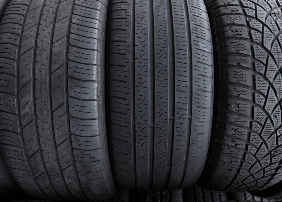 A lineup of three tires, upright, facing the viewer. Each tire is a different size with a distinct tread pattern.