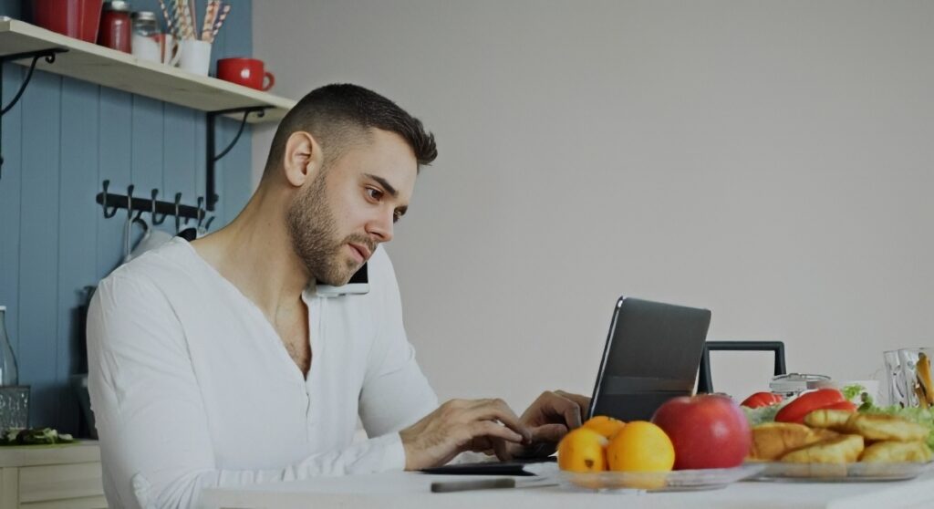 A person placing an online order on a laptop at a kitchen table
